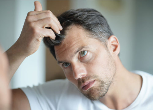 Photo of a man touching his hair